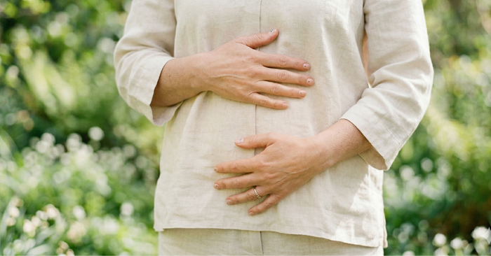 woman holding gut outside in spring